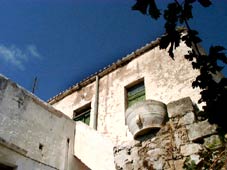 Traditional Cretan whitewashed house beneath cobalt skies